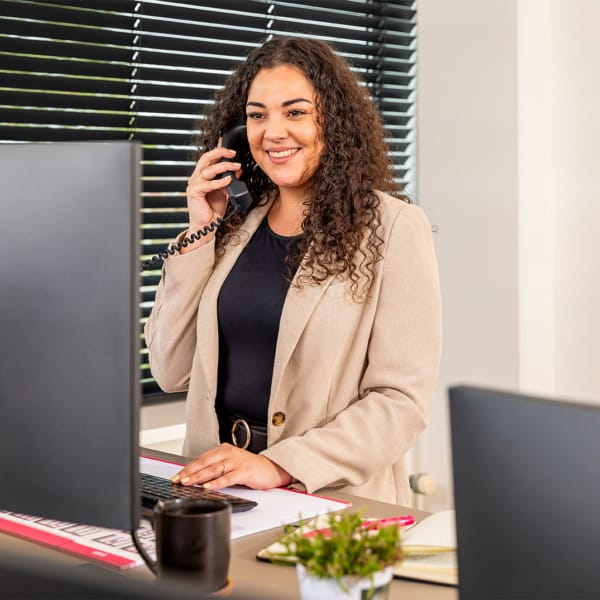 Iemand achter een bureau die aan het bellen is